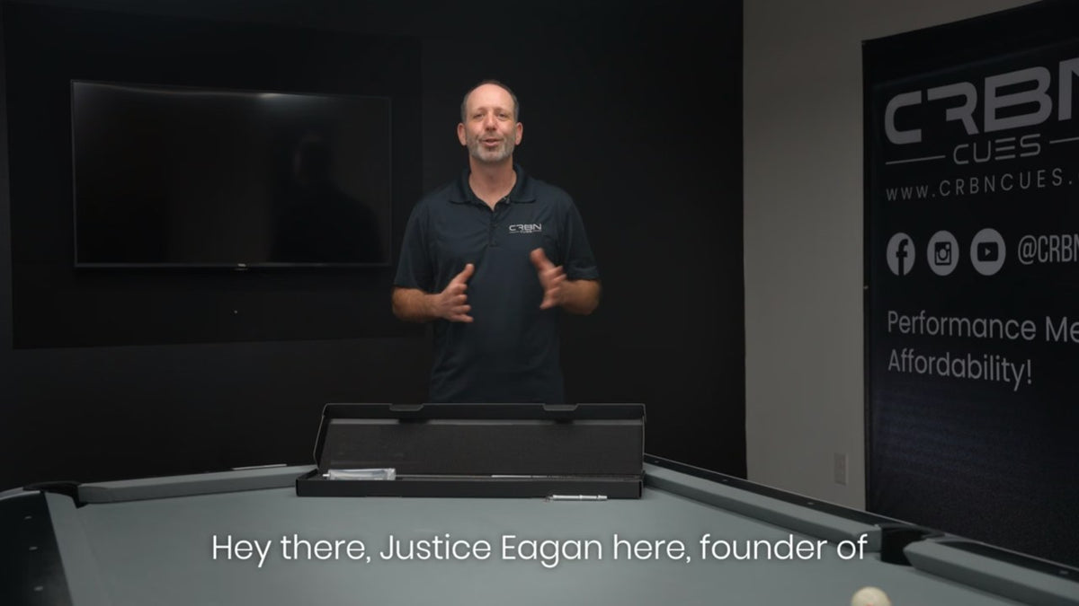 Justice Eagan, founder of CRBN Cues, standing behind a pool table with an open CRBN cue box