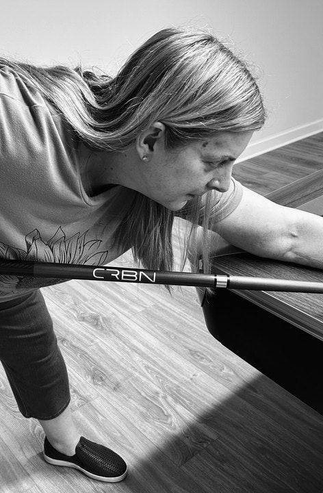CRBN Cues customer lining up a shot with her CRBN cue