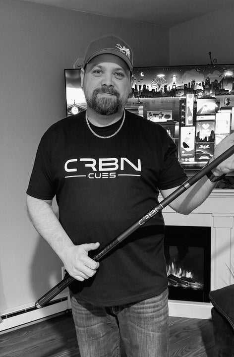 CRBN Cues customer in a cap and CRBN Cues shirt holding his CRBN cue